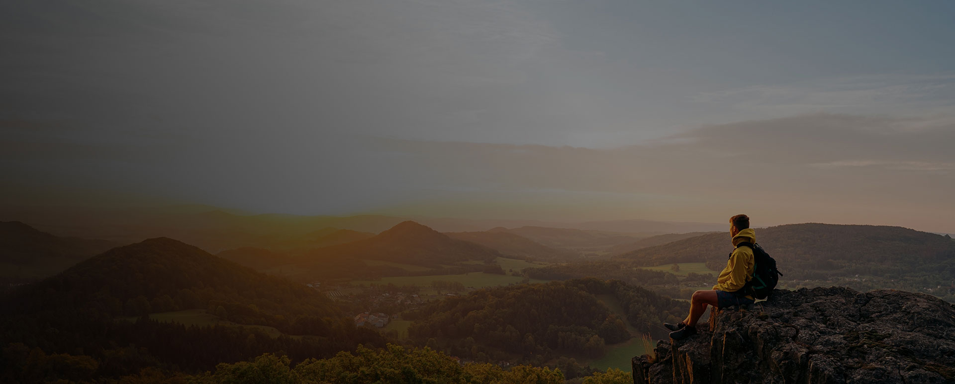 Man siting on edge of a peak