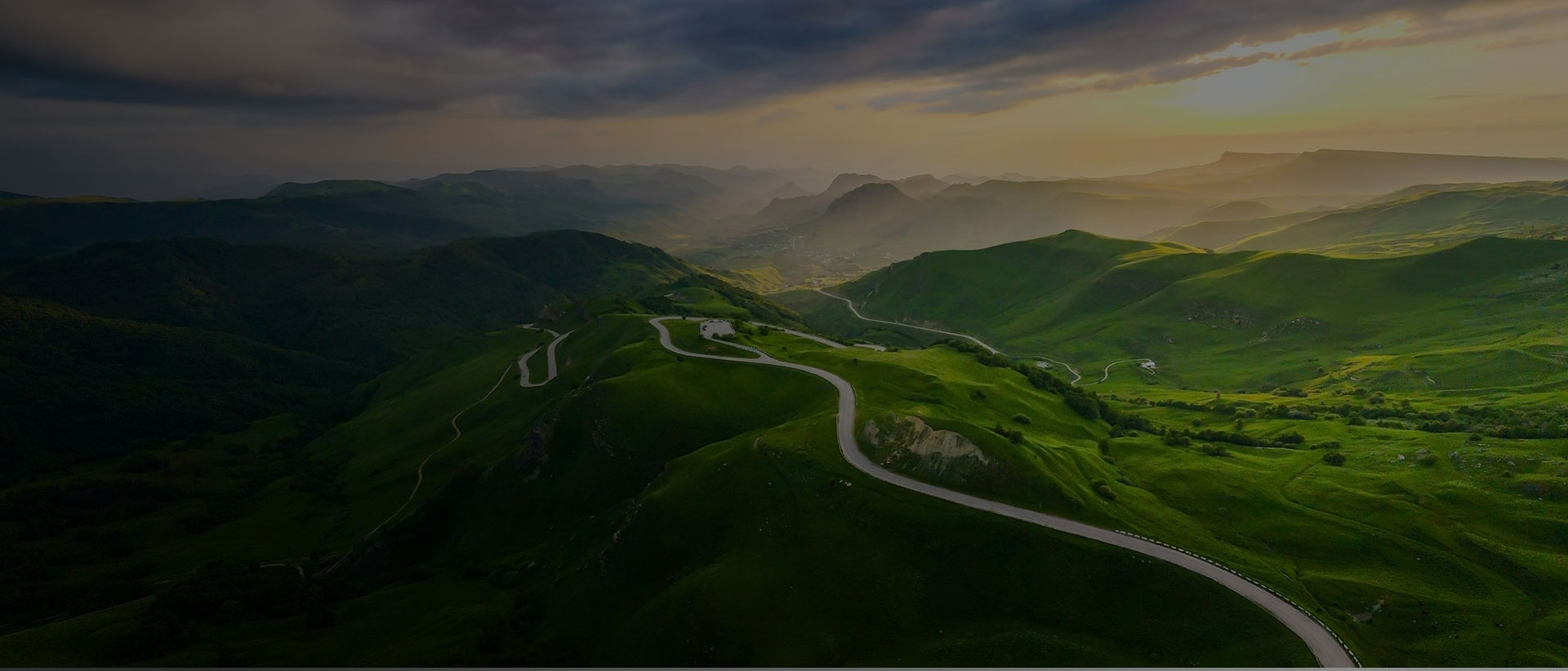 Road between green fields